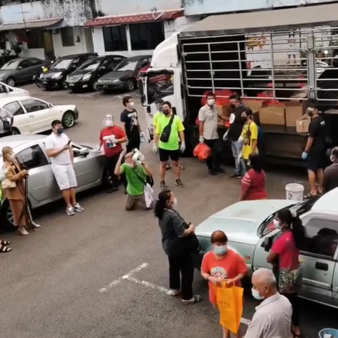 Volunteer pleads with the public to not scuffle for supplies on his knees