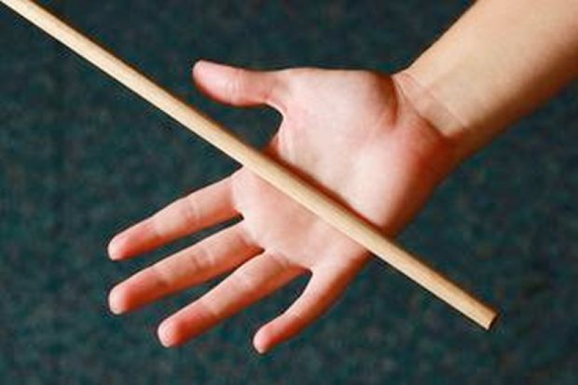 A person's hand getting caned