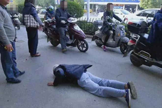 China man falls in the middle of the road