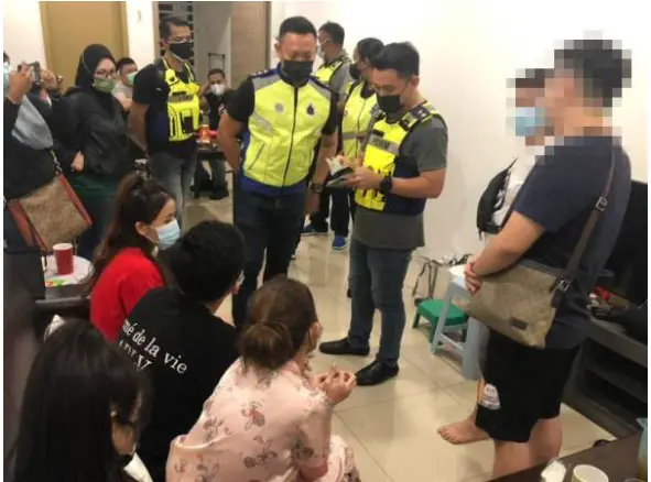 Officers checking the documents of the Vietnamese women at a luxurious condo located at Jalan Prai, Penang.